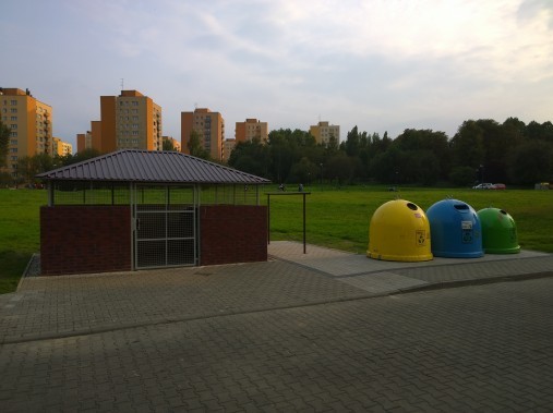 Kolorowe pojemniki do segregacji śmieci oraz zabudowany pojemnik na odpady komunalne zmieszane