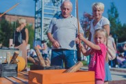 Industriada 2021 Park Tradycji industrialny plac zabaw z bawiącą się rodziną w tle budynek Parku…