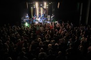 Sala widowiskowa SCK na Bytkowe, wypełniona stojącą publicznością. W centrum scena z grającym…