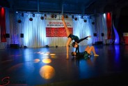 2 cheerleaderki w czarnych strojach podczas tańca na  tle flagi Mistrzostw Polski w Cheerleadingu…