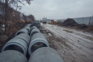 Teren budowy nowego połączenia drogowego, po lewej stronie betonowe rury melioracyjne.