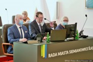 Członkowie prezydium Rady Miasta siedzący za stołem prezydialnym w dużej sali siemianowickiego…