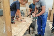 Uczniowie przycinają materiały budowlane