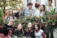 Grupa uczniów na tle kwiatów
