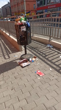 Przepełniony śmietnik przy galerii.