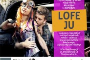 Na plakacie rudowłosa kobieta ubrana w undustrialny sposób. Tuż za nią stoi i całuje ją w ramię…