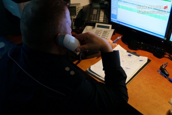 Policjant przed monitorem komputera