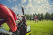 Wózek , w oddali gracz na polu golfowym