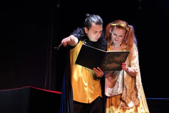 Bohaterowie spektaklu dla dzieci, rodzeństwo które czyta coś w skupieniu z magicznej księgi