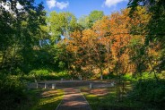 Park ludowy u schyłku lata - w tle nowe ławki i kosze na śmieci.