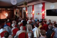 Szeroki kadr. Plan pierwszy widownia. Wgłębi scena i śpiewający artysta