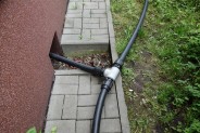 Fragment instalacji wodociągowej na chodniku obok budynku