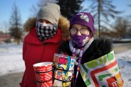 Dwie wolontariuszki w ciepłych kurtkach i czapeczkach