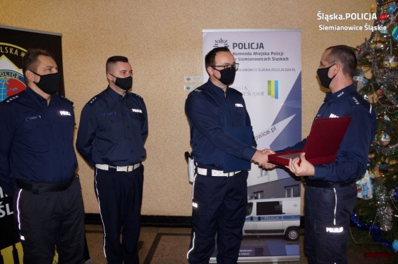 Dowódca jednostki wręcza wyróżnionemu policjantowi list gratulacyjny ministra
