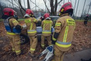 Strażacy przy uszkodzonym samochodzie