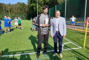 Sekretarz Miasta Siemianowice Śląskie wręczający statuetkę najlepszemu bramkarzowi na tle boiska…
