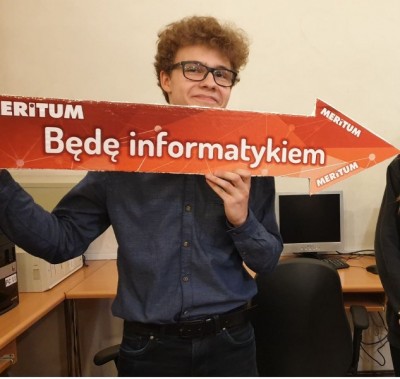 Uczeń trzymający strzałkę z napisem "Będę informatykiem"