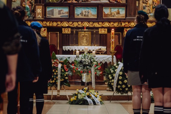 Urna z prochami Henryka Falkusa w kościele, obok wieńce żałobne, w tle ołtarz