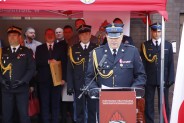 Dotychczasowy komendant przemawia stojąc przy mównicy. W tle zaproszeni goście