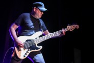 Mężczyzna w czapce, grający na gitarze basowej