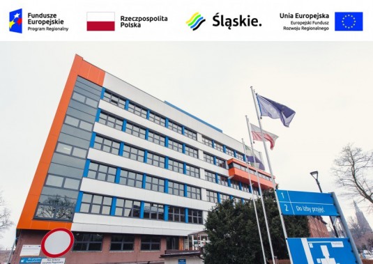 Front budynku szpitala miejskiego z odnowioną elewacją w kolorze białym, pomarańczowym i…
