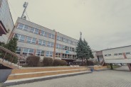 Front budynku głównego Zespołu Szkół Sportowych z oknami. Przed budynkiem są schody, a po jego…