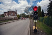 Po prawej stronie tymczasowa sygnalizacja świetlna przy ulicy Wiejskiej, wskazująca czerwone…