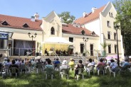 Na zdjęciu michałkowicki zameczek na tarasie którego znajdują się pod namiotem artyści na…
