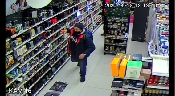 Mężczyzna zabierający perfumy z półki