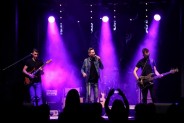Widok na scenę SCK Bytków na której występuje zespół Gutek. Po obu stronach gitarzyści, w środku…