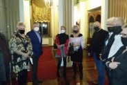 Goście wernisażu Sybilli Nowak w SCK Willi Fitznera stoją w holu obiektu, w maseczkach.