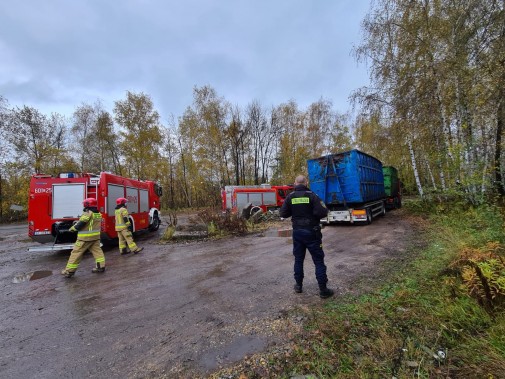 Porzucona naczepa  oraz wóz strażacki. Przy nich funkcjonariusze PSP oraz policji