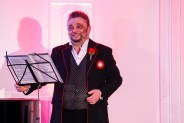 Juliusz Ursyn Niemcewicz ubrany w czarną marynarkę z biało czerwonym kotylionem i różą w klapie…
