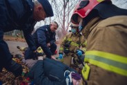 Policjanci i strażacy przy leżącym mężczyźnie