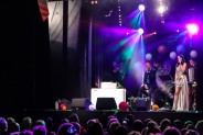 Widok na widownię i scenę SCK podczas koncertu z okazji Dnia Matki. Wokalista siedzi na scenie i…