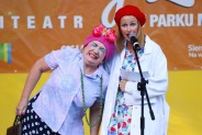 Kabaret Moherowe Berety w osobach dwóch aktorek stojących na scenie amfiteatru. Mają krzykliwe…