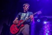 Mężczyzna grający na elektrycznej gitarze w kolorze czerwonym