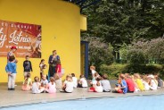 Animacje dla dzieci na scenie amfiteatru. Widzimy z daleka scenę na której siedzą dzieci,…