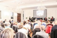 Publiczność podczas spotkania z Gabrielą Kańtor, na scenie przy czarnym fortepiaanie pianistka…