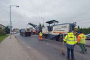 Remont ulicy Wrocławskiej. Na pierwszym planie drogowcy, w tle frezarka frezująca asfaltową jezdnię.