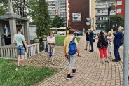 Zdjęcie przedstawia grupę ludzi pod pomnikami i kapliczkami biorących udział w Historycznym…