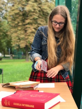 Uczennica przykłada pamiątkową pieczęć