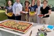Grupa świętujących przy torcie jubileuszowym