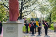 Poczet sztandarowy siemianowickiej Straży Miejskiej przed figurą św. Floriana.