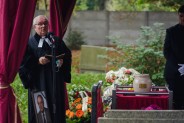 Pastor modlący się nad grobem przy urnie