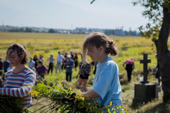 Młodzież porządkująca teren cmentarza
