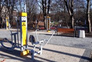 Sprzęt do ćwiczeń siłowni na wolnym powietrzu, nowa ławka i kosz na śmieci posadowione wzdłuż…