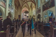 Poczet sztandarowy idący w stronę ołtarza