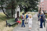Zdjęcie przedstawia grupę ludzi pod pomnikami i kapliczkami biorących udział w Historycznym…