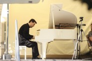 Pianista Michał Kryworuczko siedzący przy białym fortepianie na tarasie SCK Zameczek